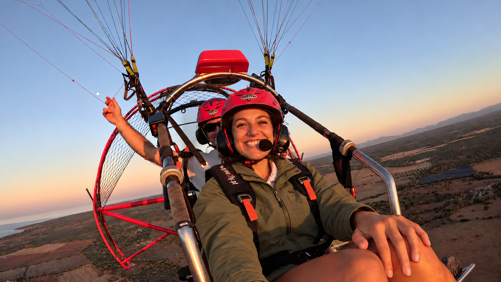 Pasajera sonríe durante un vuelo biplaza en Paratrike en Mallorca al atardecer.
